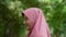 Closeup face of cheerful woman covered with headscarf smiling outdoors. Casual Islamic girl at the park. Freedom and relaxing