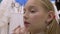 Closeup face girl teenager while makeup lips in salon. Lips makeup concept