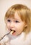 Closeup face of little girl eating pasta by a fork