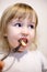 Closeup face of little girl eating pasta by a fork