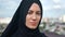 Closeup face Muslim woman in black headscarf posing outdoor at Islamic city blue sky global freedom