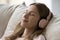 Closeup face of peaceful woman listen music through wireless headphones