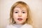 Closeup face portrait of cute two years old white girl on wall background