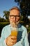 Closeup face portrait of old man drinking refreshment cocktail from straw