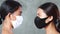 Closeup faces of two beautiful Asian women posing in medical face mask posing over concrete background