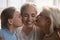 Closeup faces woman her daughter and elderly mother kiss her