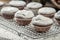 Closeup of falling powder sugar on vanilla muffins