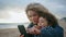 Closeup family taking selfie on cloudy beach. Beautiful young mother hugging son