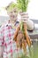 Closeup of farmer holding fresh organic carrots at farm