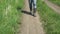 Closeup of feet. the man in canvas boots coming down the road in the field