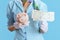 Closeup on female air hostess on blue in blue uniform with flight tickets and piggy bank