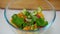 Closeup female Caucasian hand placing greenery in bowl with healthful organic salad in slow motion. Close-up