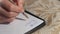 Closeup female Caucasian hand writing words in Spanish on white paper. Close-up unrecognizable woman handwriting amor