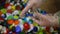 Closeup female Caucasian hands in gloves showing multicolored plastic bottle caps. Unrecognizable young woman volunteer