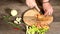 Closeup of female chef hands slicing peeled carrots on a wooden cutting board next to sliced vegetables. The concept of