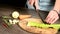 Closeup of female chef hands slicing peeled Celery on a wooden cutting board next to sliced vegetables. The concept of