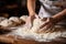 closeup of a female chef\\\'s hands making dough on a wooden table