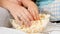 Closeup of female and child's hand taking popcorn from big glass bowl