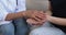 Closeup of female doctor holding and stroking woman patient hands