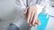 Closeup of a female doctor in hospital waring white uniform is rubbing palm with sanitizer alcohol gel washing hand to prevent