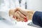 Closeup of a female doctor`s and patient`s hands. Discussing treatment with a patient and handshake after finding a solution and