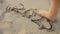 Closeup of female feet walking over the 2023 year written on wet sand at sea beach.