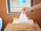 Closeup female hand picking a white tissue from tissue box.