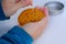 Closeup female hand scratches with needle yellow caramel sugar cookies with embossed star for popular Korean children`s game, cut