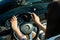 Closeup on female hands driving Mercedes Benz car luxury transportation lifestyle. Mercedes