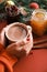 Closeup female hands holding hot chocolate near jam jars. Sweet breakfast Christmas morning