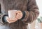 Closeup of female hands with a pink mug coffee beverage. Beautiful girl in grey sweater holding cup of tea or coffee