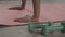 Closeup of female hands on a pink rug for yoga. Concept of domestic training. On the floor lie races and rope