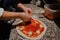 Closeup of female hands putting meat on pizza in the kitchen, pizza cooking process