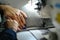 Closeup of female hands sewing gray leather on a machine