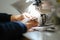 Closeup of female hands sewing gray leather on a machine