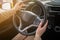 Closeup of female hands on a steering wheel. Driving on a sunny day