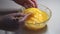 Closeup of female hands stirring eggs in glass bowl with chopsticks, slow motion