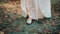 Closeup female legs shoes white dress vintage style. woman steps walks in forest