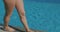 Closeup of female legs walking by the outdoor pool