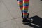 Closeup of female legs wearing rainbow socks and sneakers