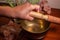 Closeup of a female\'s hand holding a stick of a Tibetan handcrafted singing bowl