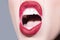 Closeup female screaming mouth. Open mouth, red lips, white teeth. Scream concept.