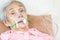 Closeup of female senior patient putting inhalation or oxygen mask in hospital bed or home,sick elderly asian woman undergoing