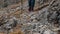 Closeup of Female Traveler Crossing Rocky Terrain