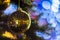 Closeup of Festively Decorated Outdoor Christmas tree with bright gold ball on blurred sparkling fairy background. Defocused