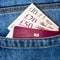 Closeup of fifty, twenty, ten pounds sterling banknotes and EU passport peeking out of blue jeans back pocket