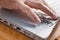 Closeup of fingers touching keyboard on wood table