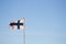 Closeup of the flag of Finland waving on a pole against a blue sky