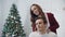 Closeup flirting wife massaging husband in christmas decorated room