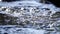 Closeup of flowing water in the mountain under sunlight, sparkling water surface